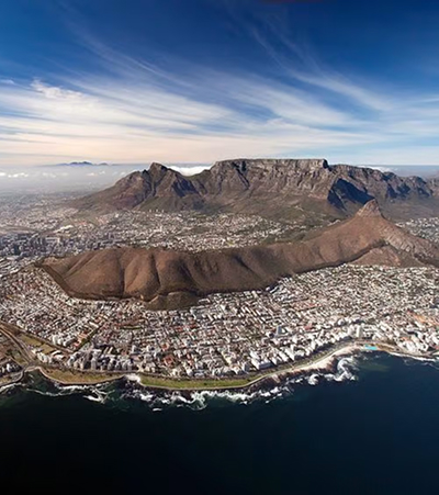 Why Planning Your Time Matters Aerial view of Table Mountain over the city of Cape Town, with houses along a rocky coastline.